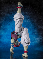 A collectible action figure of Akaza posed upside down in a handstand-like pose against a dark blue textured studio background. The figure has pale skin, white draped clothing, blue striped accents, red beaded ankle accessories, and a purple-and-red waist detail.
